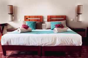 a bedroom with a large bed with blue pillows at La Perle du Lagon in Le François