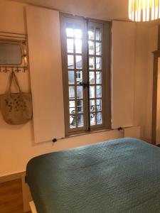 a bedroom with a green bed and a window at Au COCON QUIMPEROIS in Quimper