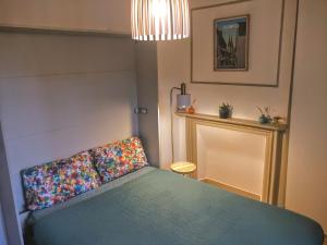 a bedroom with a green bed with a colorful pillow at Au COCON QUIMPEROIS in Quimper