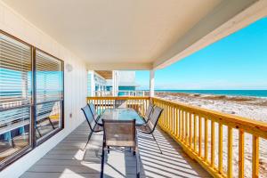 uma varanda com mesa e cadeiras na praia em The Beach House em Gulf Shores