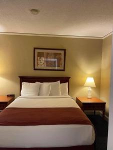 a large bed in a hotel room with two tables at Senate Luxury Suites in Topeka
