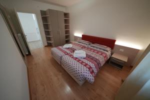a small bedroom with a bed with a red headboard at cima Monticelli in Passo del Tonale