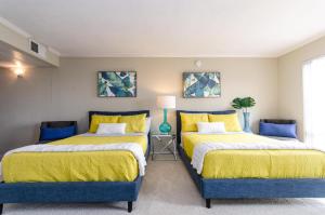 two beds in a room with yellow and blue at Savana spectacular loft in Los Angeles