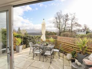 a patio with a table and chairs and a sliding glass door at Ty Mawr in Menai Bridge