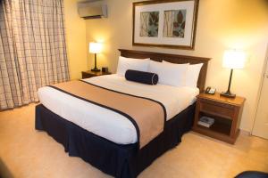 uma cama grande num quarto de hotel com duas lâmpadas em Best Western El Dorado Panama Hotel na Cidade do Panamá