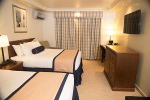 a hotel room with two beds and a desk at Best Western El Dorado Panama Hotel in Panama City