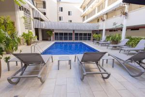 a courtyard with a pool and chairs and a swimming pool at Best Western El Dorado Panama Hotel in Panama City