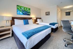 Tempat tidur dalam kamar di Albany Motel & Apartments