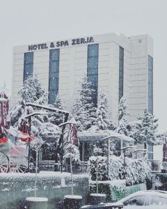 un hotel en la nieve frente a un edificio en Resort Zerja and Spa, en Peshkopi