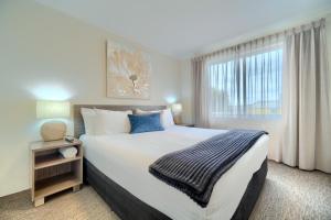 a bedroom with a large bed and a window at Albany Motel & Apartments in Albany