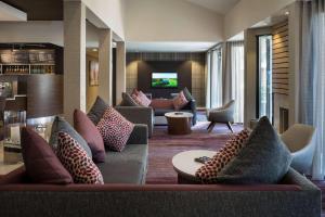 a hotel lobby with couches and a tv at Sonesta Select Los Angeles LAX El Segundo in El Segundo