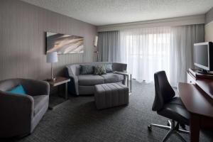 a hotel room with a couch chair and a television at Sonesta Select Los Angeles LAX El Segundo in El Segundo +32 photos