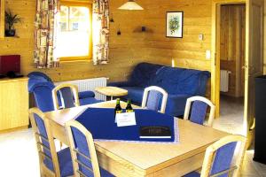 a dining room with a table and a blue couch at Holiday Village Schlierbach in Schlierbach