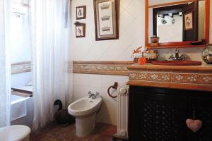 een badkamer met een toilet, een wastafel en een spiegel bij holiday home Casa El Moral, Arico - La Sabinita in La Degollada