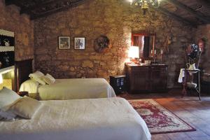 een slaapkamer met 2 bedden en een stenen muur bij holiday home Casa El Moral, Arico - La Sabinita in La Degollada