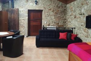a living room with a black couch with red pillows at Holiday Home Vale de Cambra - PON03240-F in Vale de Cambra