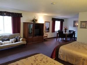 a hotel room with a bed and a couch and a table at Keystone Boardwalk Inn and Suites in Keystone