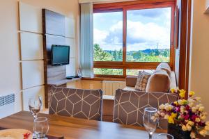 sala de estar con mesa y ventana grande en LOCAR-IN GRAMADO - Residencial Maranello, en Gramado
