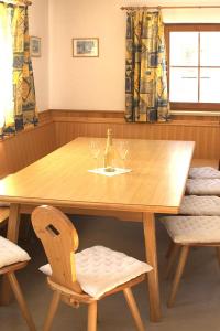 einen Holztisch mit zwei Gläsern und zwei Stühlen in der Unterkunft Feriendorf am Feuerkogel, Ebensee in Ebensee