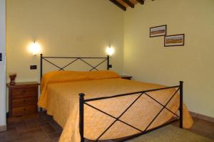 沃爾泰拉的住宿－Farmhouse stay Giulia Volterra，一间卧室配有一张带橙色床罩的床