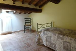 沃爾泰拉的住宿－Farmhouse stay Giulia Volterra，一间卧室,卧室内配有一张床和一把椅子