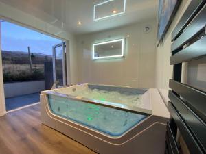 a jacuzzi tub in a room with a window at Highland Stays - Ben View Room & Jacuzzi Bath in Fort William