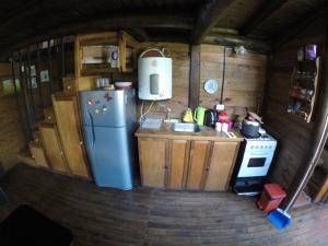 eine Küche mit einem Kühlschrank und einem Herd in einer Hütte in der Unterkunft La Cabaña de la casona in Don Torcuato