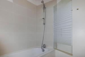 ein weißes Bad mit einer Dusche und einer Badewanne in der Unterkunft Apartment, Manneville-es-Plains in Manneville-ès-Plains