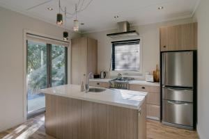 a kitchen with a sink and a refrigerator at Cardrona Valley Escape - Cardrona Holiday Home in Cardrona