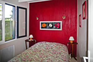 - une chambre dotée d'un mur rouge avec un lit et deux lampes dans l'établissement Holiday Home, Portbail, à Portbail