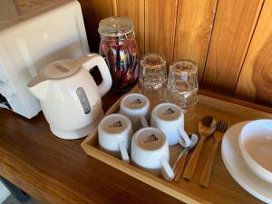 a tray with a tea kettle and cups on a table at Waraporn Valley วราภรณ์วัลเลย์ in Ban Nong Tum
