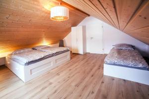 una camera con 2 letti e un soffitto in legno di Holiday home Partwitz, Elsterheide a Elsterheide