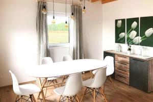 una sala da pranzo con tavolo bianco e sedie bianche di Holiday home Partwitz, Elsterheide a Elsterheide