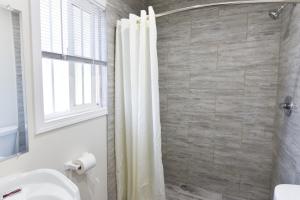 Un baño con cortina de ducha y lavabo. en Holly Park Motel near LAX, en Inglewood