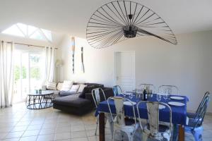 ein Esszimmer mit einem blauen Tisch und einem Ventilator in der Unterkunft Cottage, Saint Germain sur Ay in Saint-Germain-sur-Ay