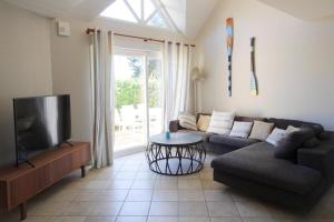 ein Wohnzimmer mit einem Sofa und einem Flachbild-TV in der Unterkunft Cottage, Saint Germain sur Ay in Saint-Germain-sur-Ay