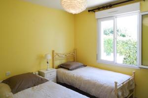 1 dormitorio con 2 camas y ventana en Cottage, Saint Germain sur Ay en Saint-Germain-sur-Ay