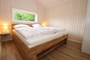 a large bed in a room with a window at Ferienhaus Larsson mit Sauna am Dümmer See, Dümmer in Dümmer