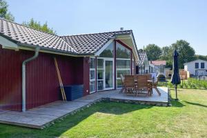 a deck with a table and chairs in a yard at Ferienhaus Larsson mit Sauna am Dümmer See, Dümmer in Dümmer