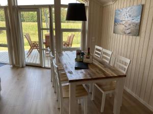 a dining room with a wooden table and chairs at Ferienhaus Larsson mit Sauna am Dümmer See, Dümmer in Dümmer +17 photos