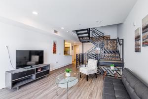 a living room with a couch and a staircase at Heaven on Hollywood Furnished Apartments in Los Angeles