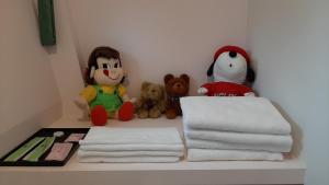 un estante con toallas y animales de peluche. en Dong Hua Dream House, en Pinghe