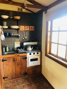 cocina pequeña con fogones y ventana en Dorotea Vista en Puerto Natales