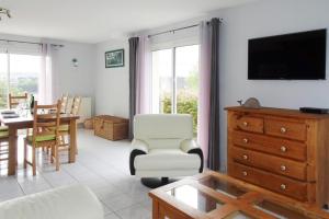 a living room with a tv and a dining room at Holiday Home in Paimpol near Beach in Paimpol