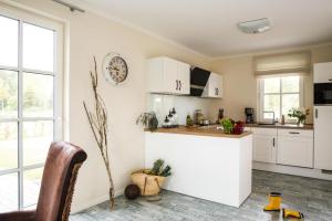 a kitchen with white cabinets and a counter at Holiday house, Fuhlendorf in Fuhlendorf