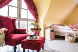 a bedroom with a red chair and a bed at Holiday house, Fuhlendorf in Fuhlendorf