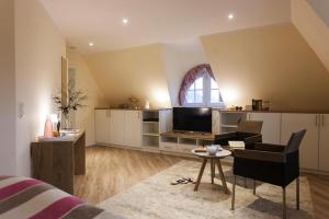 a living room with a bed and a tv and a table at Holiday house, Fuhlendorf in Fuhlendorf