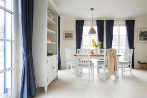 uma sala de jantar com cortinas azuis e uma mesa e cadeiras em Holiday house, Fuhlendorf em Fuhlendorf