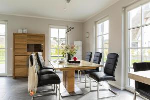 a dining room with a wooden table and black chairs at Holiday house, Fuhlendorf in Fuhlendorf