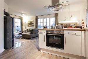 a kitchen with a stove top oven next to a living room at Holiday house, Fuhlendorf in Fuhlendorf